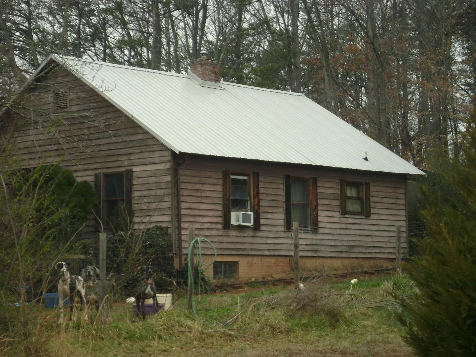 White metal roof on an old wood sided farmhouse, from a Asphalt Shingle Roof Repair job in Cherokee